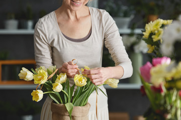 Woman decorating bouquet of tulips