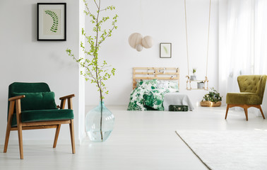 Open bedroom with green armchair