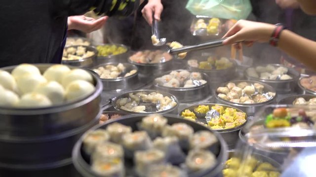 4K Vendor preparing and selling Shaomai and customers at Asian Street Food Market in Taiwan. Dumpling is a chinese traditional food at Oriental Night Market. Restaurant in downtown-Dan