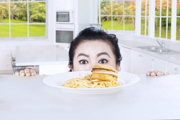 Head of woman with hamburger in the kitchen