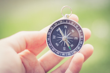 Kompass in Männerhand, draußen, Bokeh
