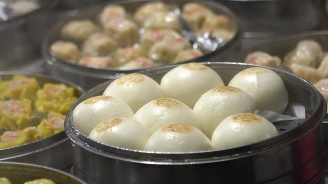 Slow motion vendor preparing and selling Shaomai and customers at Asian Street Food Market in Taiwan. Dumpling is a chinese traditional food at Oriental Night Market. Restaurant in downtown-Dan