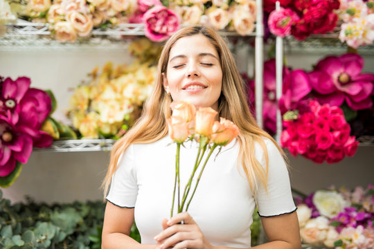 Young Woman Smelling Roses