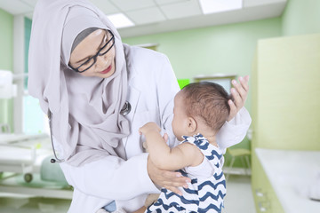 Muslim doctor examining a baby