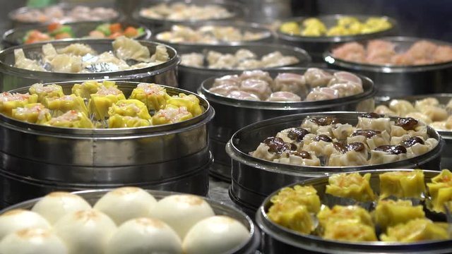 Slow motion vendor preparing and selling Shaomai and customers at Asian Street Food Market in Taiwan. Dumpling is a chinese traditional food at Oriental Night Market. Restaurant in downtown-Dan