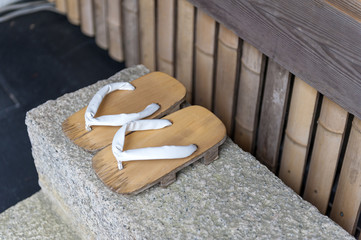 Fototapeta na wymiar Geta or traditional Japanese footwear, a kind of flip-flops or sandal with an elevated wooden base held onto the foot with a fabric thong strap
