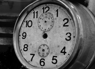 A very old and damaged clock without hands. Black and white.
