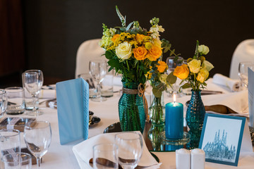 Beautifully decorated wedding table with yellow roses and candles