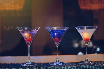 cocktail in martini glasses in front of the night club bokeh lights. Party and celebrate concept 