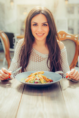 Young woman enjoying food in a restaurant, having her lunch break