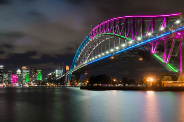 Obraz na płótnie Canvas Long exposure night shot of the city center of the Sydney skyline looking over the harbor bridge during vivid