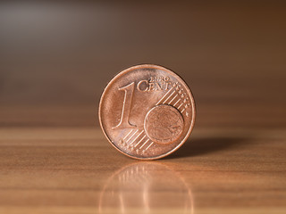 one euro cent standing on a wodden table