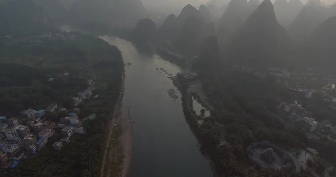 Aerial shot of passenger boats,rafts in beautiful Li River surrounded by karst mountains at sunset or sunrise in Yangshuo,Guilin,China. Travel, picturesque famous destination and adventure concept.