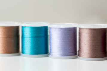 row of colorful thread spools on table