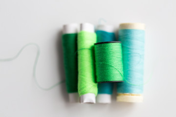 green and blue thread spools on table
