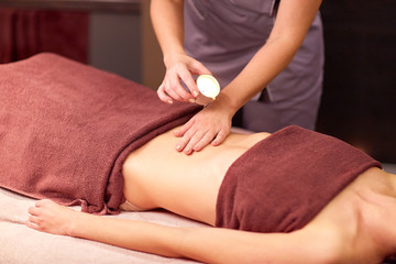 woman lying and having massage with hot oil at spa