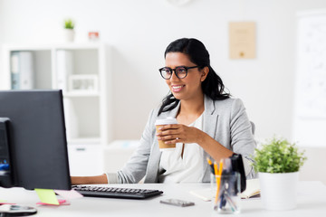 Obraz na płótnie Canvas businesswoman drinking coffee at office computer