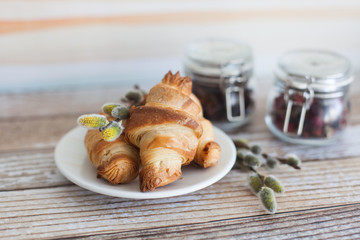 Tasty croissants with spikelets on grey wooden background