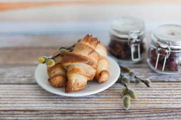 Tasty croissants with spikelets on grey wooden background