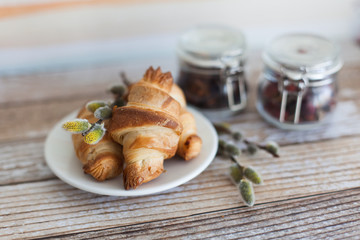 Tasty croissants with spikelets on grey wooden background