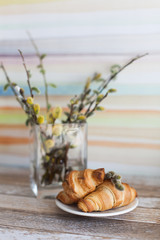 Tasty croissants with spikelets on grey wooden background
