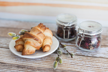 Tasty croissants with spikelets on grey wooden background