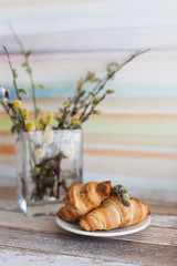 Tasty croissants with spikelets on grey wooden background