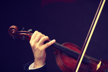 Man man dressed elegantly playing violin