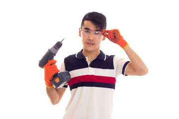 Young man with gloves and glasses holding electric screwdriver