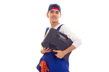 Young man in overall holding toolbox