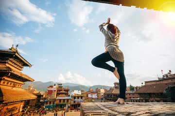 A hipster Thai woman doing yoga post at the ancient city in Nepal.