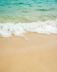 Fototapeta na wymiar summer background of blue wave on the sandy beach