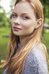 Naklejka premium Beautiful red hair ginger slim young woman with fresh skin in casual outfit, posing. Sunny summer day in park (nature). Daylight