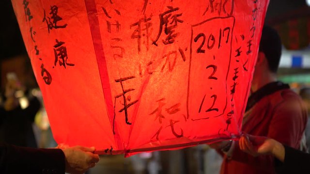 4K People launching asian lanterns during buddhist festival, rice paper hot air balloons are launched during traditional flying lantern from Pingxi in Taiwan-Dan