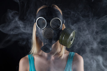 Portrait of woman in gas mask and smoke