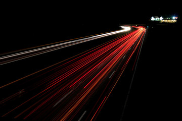 Fototapeta na wymiar Cars streaking by on the interstate at night.