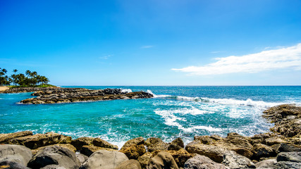 Waves breaking on the barriers of the lagoons at the resort community of Ko Olina, on the West Coast of the Hawaiian island of Oahu, and making the blue waters of the lagoons a safe place to swim