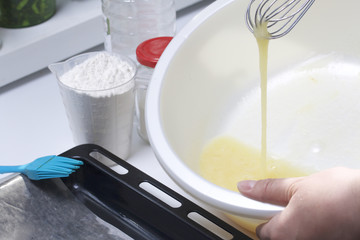 Preparation of biscuit rolls. Stages of preparation. The woman is whipping the egg and sugar.