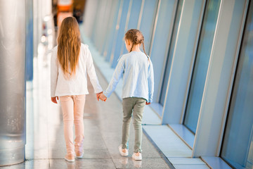 Little adorable girls in airport near big window