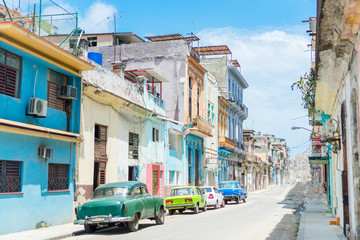 HAVANA, CUBA - APRIL 14, 2017: Authentic view of a street of Old Havana with old buildings and cars