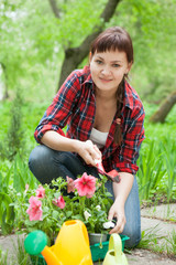 Young woman planting flowers in garden.