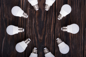 Led lamps lie on a wooden table.