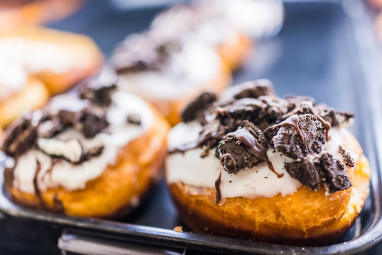 Vanilla white iced donuts with chocolate sandwich cookies crumbled on top