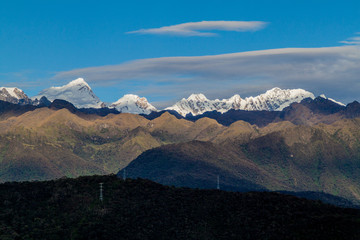 Sun is rising over snow capped mountains near Machu Picchu ruins, Peru