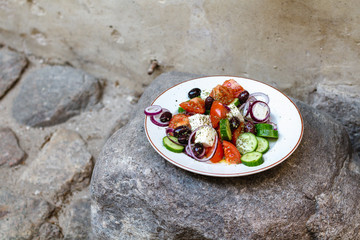Greek salad with tomatoes, cucumbers, feta, red onions, olives