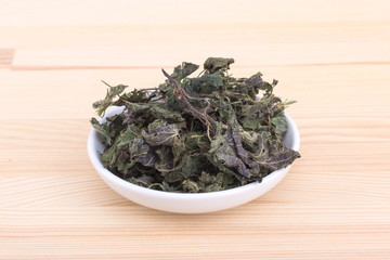  dried nettle leaves / Porcelain bowl with dried nettle leaves