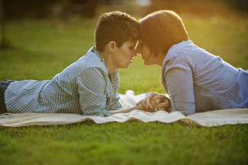 Mid adult couple lying down on a picnic blanket in a park.