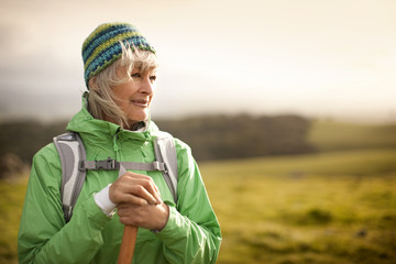 Confident mature woman hiking in the countryside.