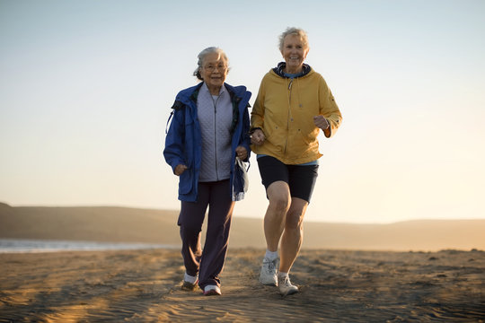 Senior Women Jogging On Beach