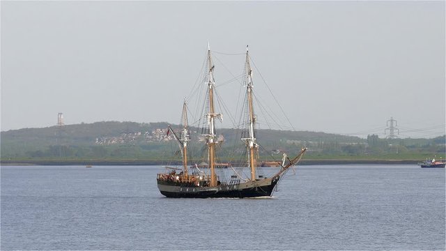 Full rigged traditional old sailing ship on calm waters